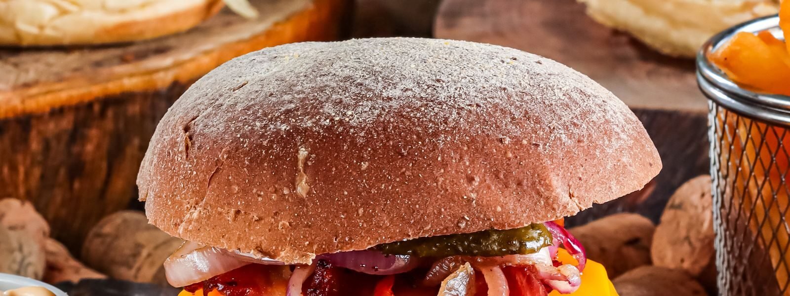 Hampurilaisia cheddarilla ja pekonilla puulaudoilla