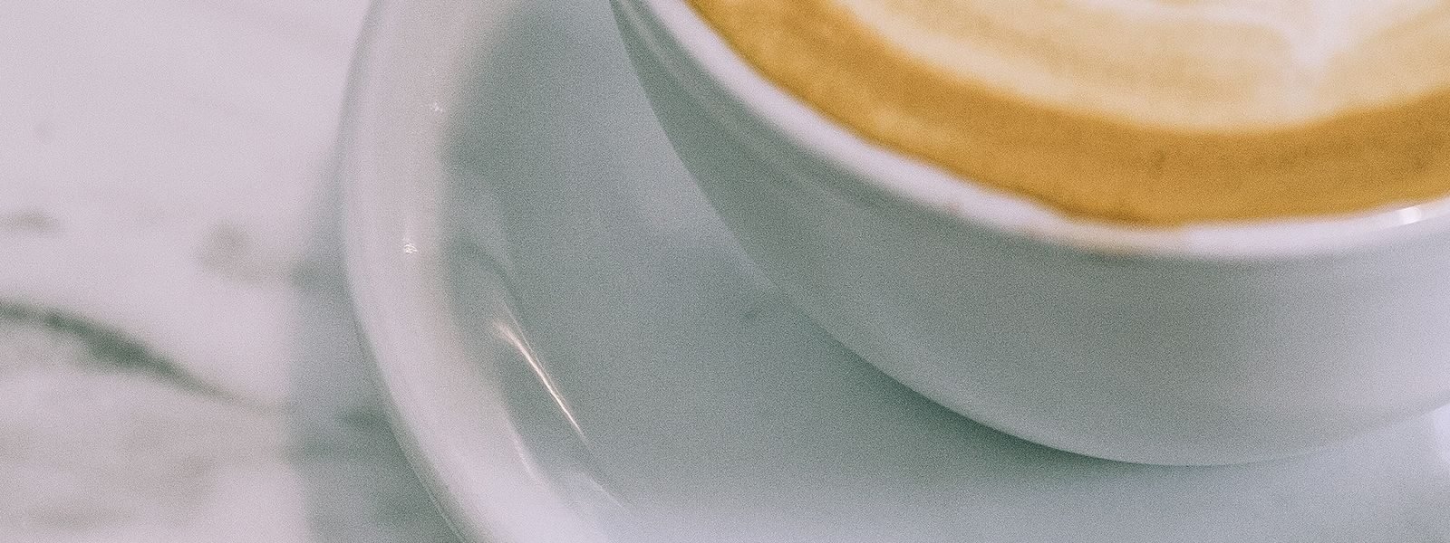 Cappuccino maitovaahtokuviolla kahvilan pöydällä